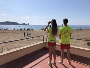 Dos socorristes de la platja de l'Estartit observen la costa amb uns prismàtics