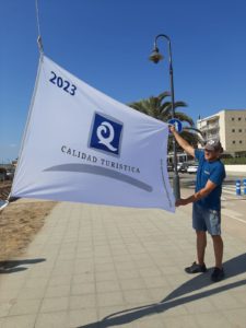 El representant d'Empesca't hissa mostra la bandera Q de Qualitat Turística